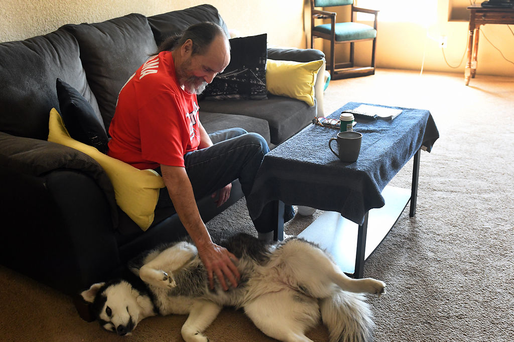 Denny Sercu gives his dog Aspen a belly rub